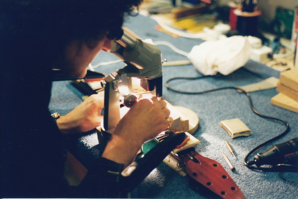Brian examines under a microscope the Red Special's 5th fret dot marker hole after the temporary red wooden dot was removed